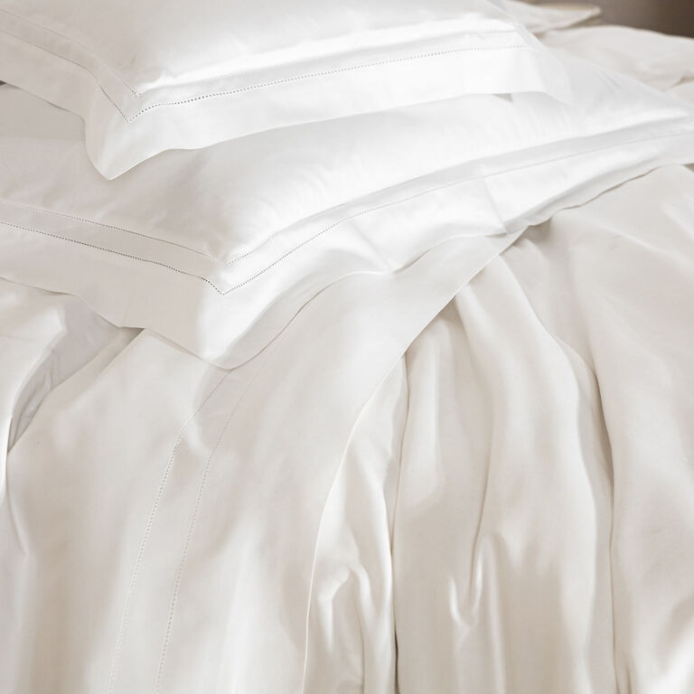 Crisp white Frette pillows and cotton sateen sheets with double open hemstitch details pair perfectly with the elegant Doppio Ajour | Duvet Cover.