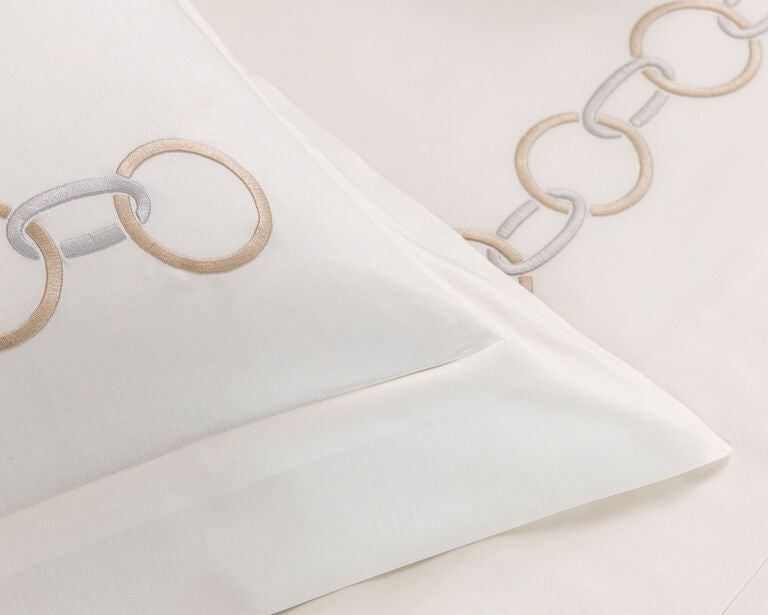 The Frette Links Embroidered Sham features a chain embroidery in beige and gray, adding an elegant touch to your luxury bedroom decor.