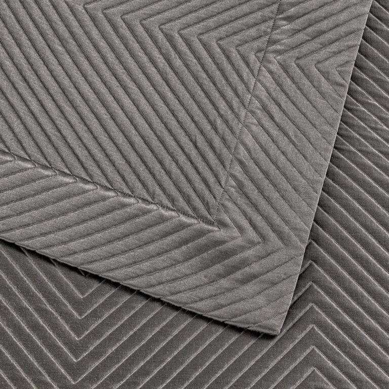 Close-up of two overlapping gray Luxe Herringbone Decorative Shams by Frette, featuring a zigzag chevron pattern and refined texture that highlights the luxury of this bedcover accessory.