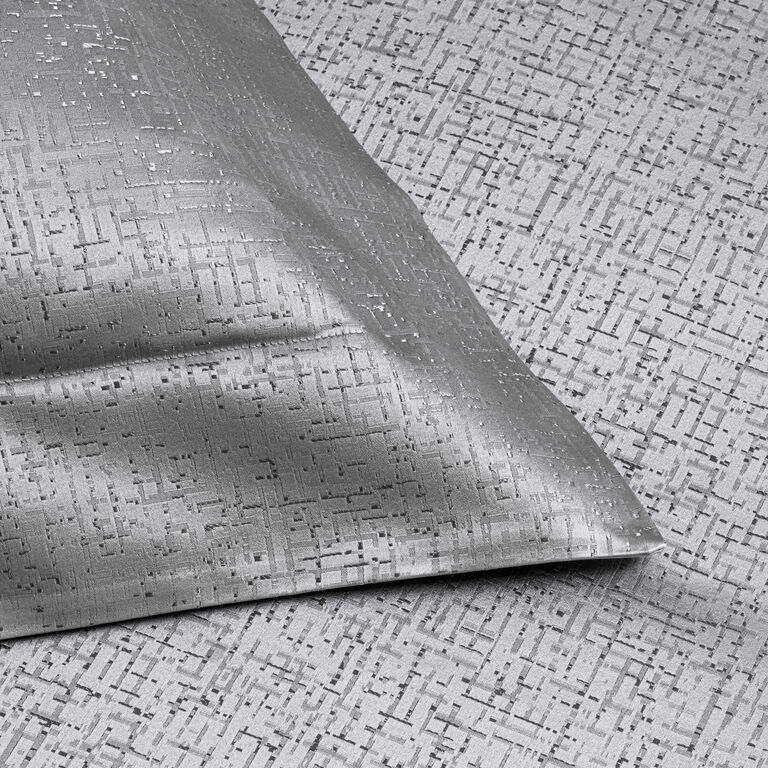 The Luxe Glowing Weave duvet cover by Frette features a silver geometric cotton and silk jacquard design, perfectly complementing a matching pillow in the same textured pattern.