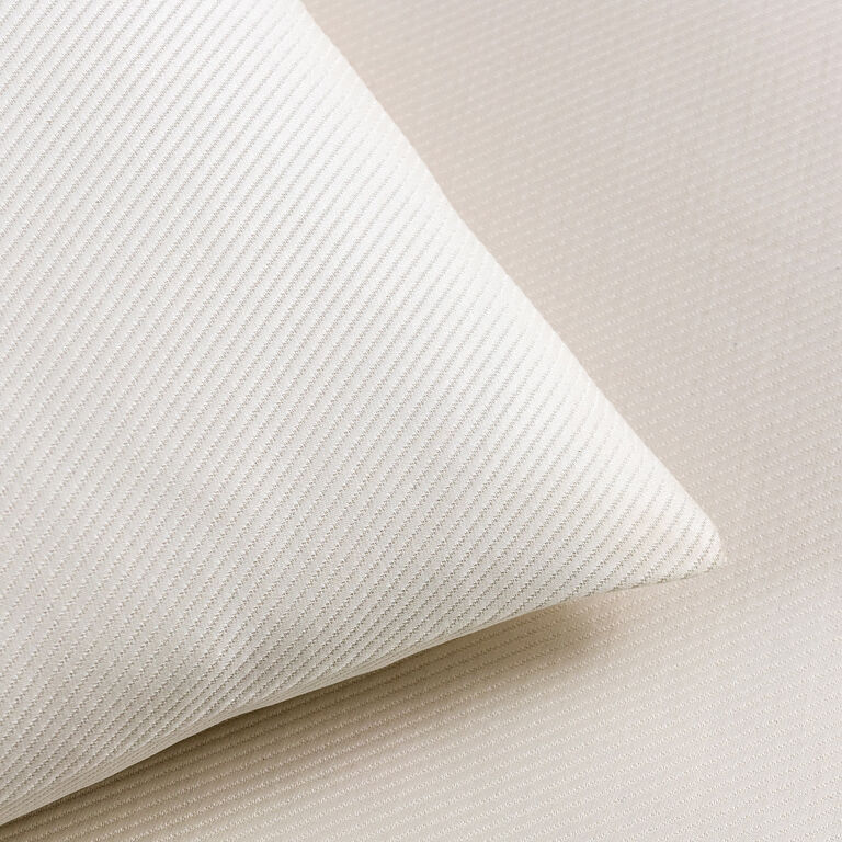 A close-up of the cream-colored Cavalry | Euro Sham by Frette on a matching textured surface, both showcasing diagonal ribbed patterns that evoke classic style.