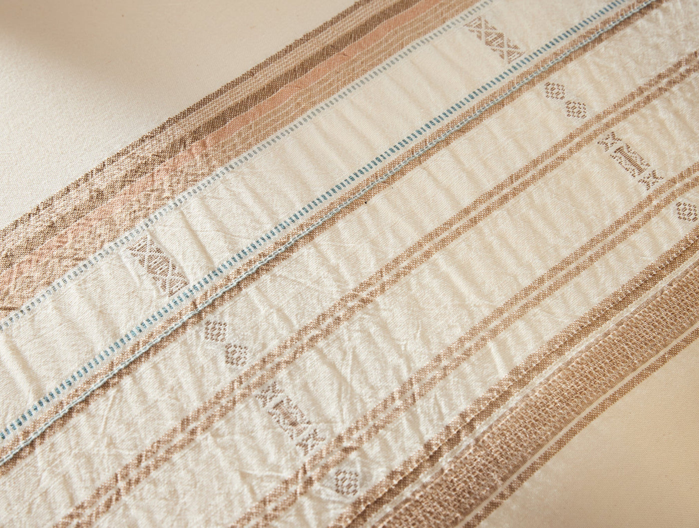 Close-up of Coyuchi Bodega Bay sham hem with woven tan and blue stripe border detail.