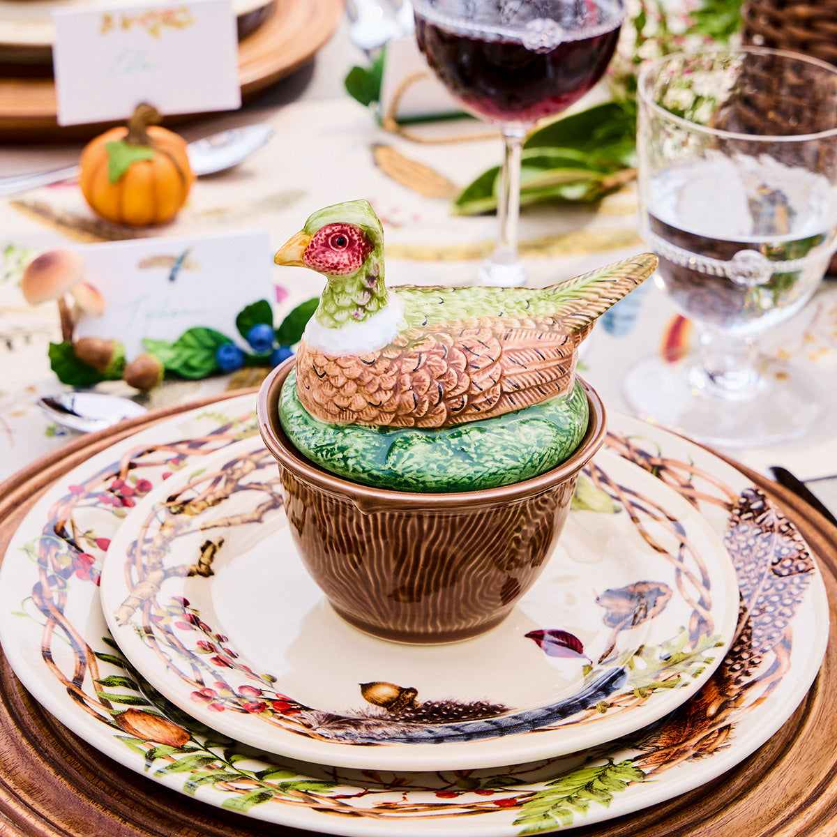 Forest Walk pheasant lidded bowl on stacked Forest Walk plates with wine glasses and a small pumpkin