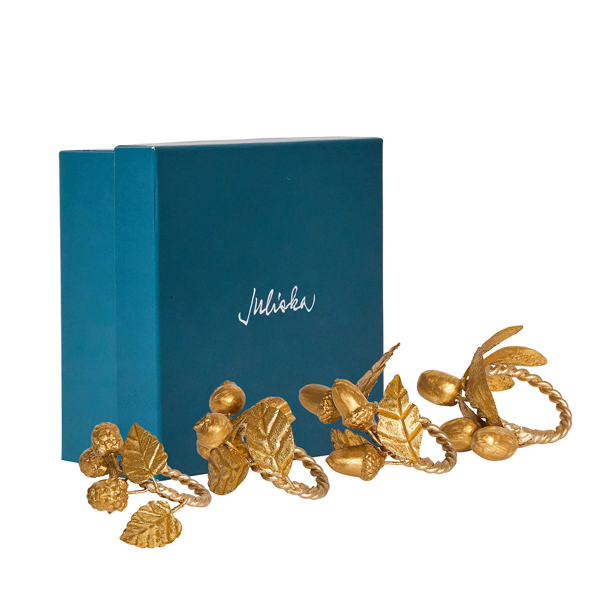 Juliska Forest Walk assorted gold leaf napkin rings in front of a teal gift box