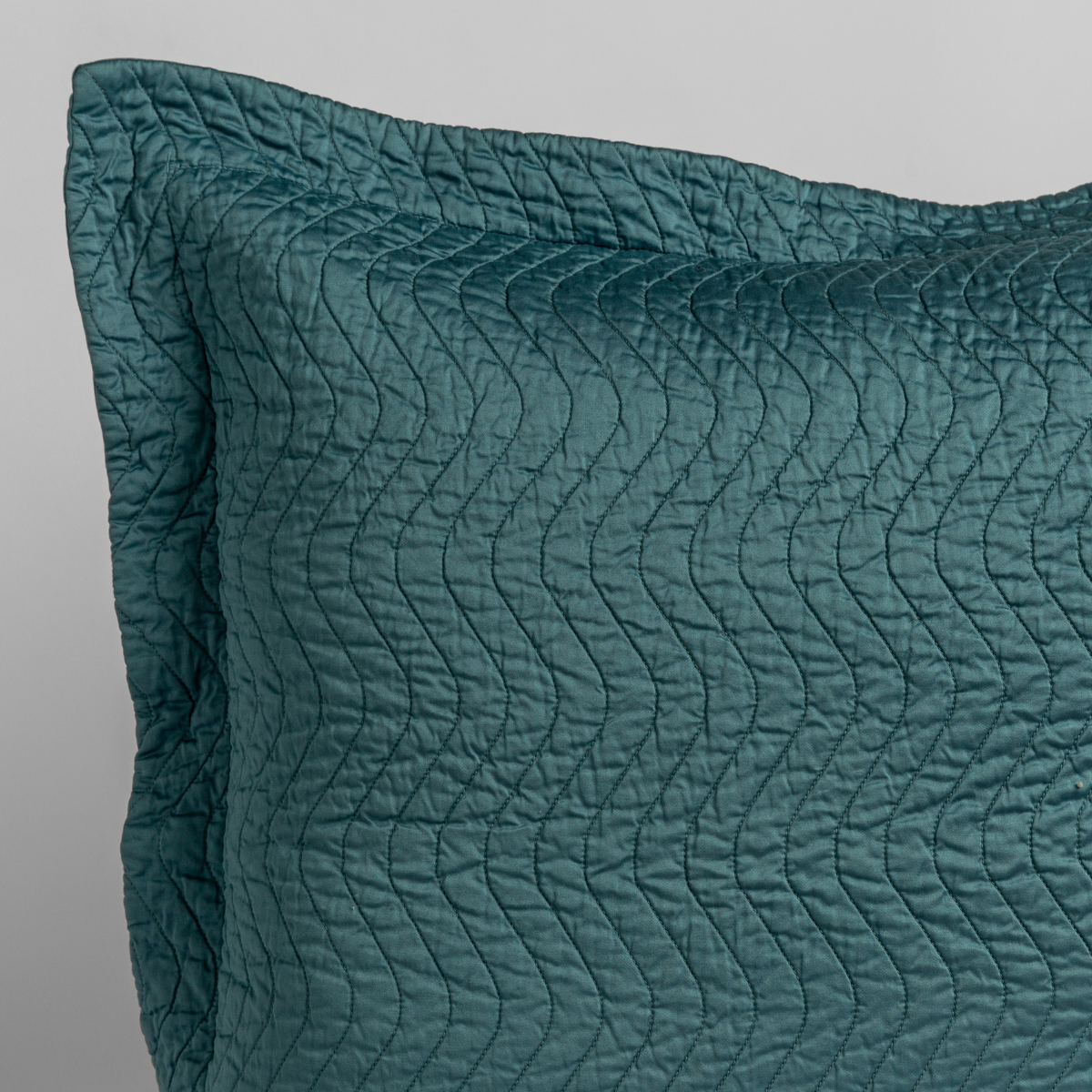 Close-up of Bella Notte Cirillo pillow sham in Cenote with wave-quilted texture detail.