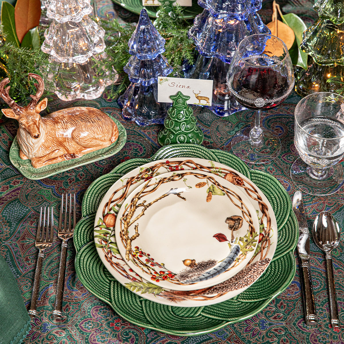 Stag place card above Forest Walk plates on a green charger with a deer figure nearby