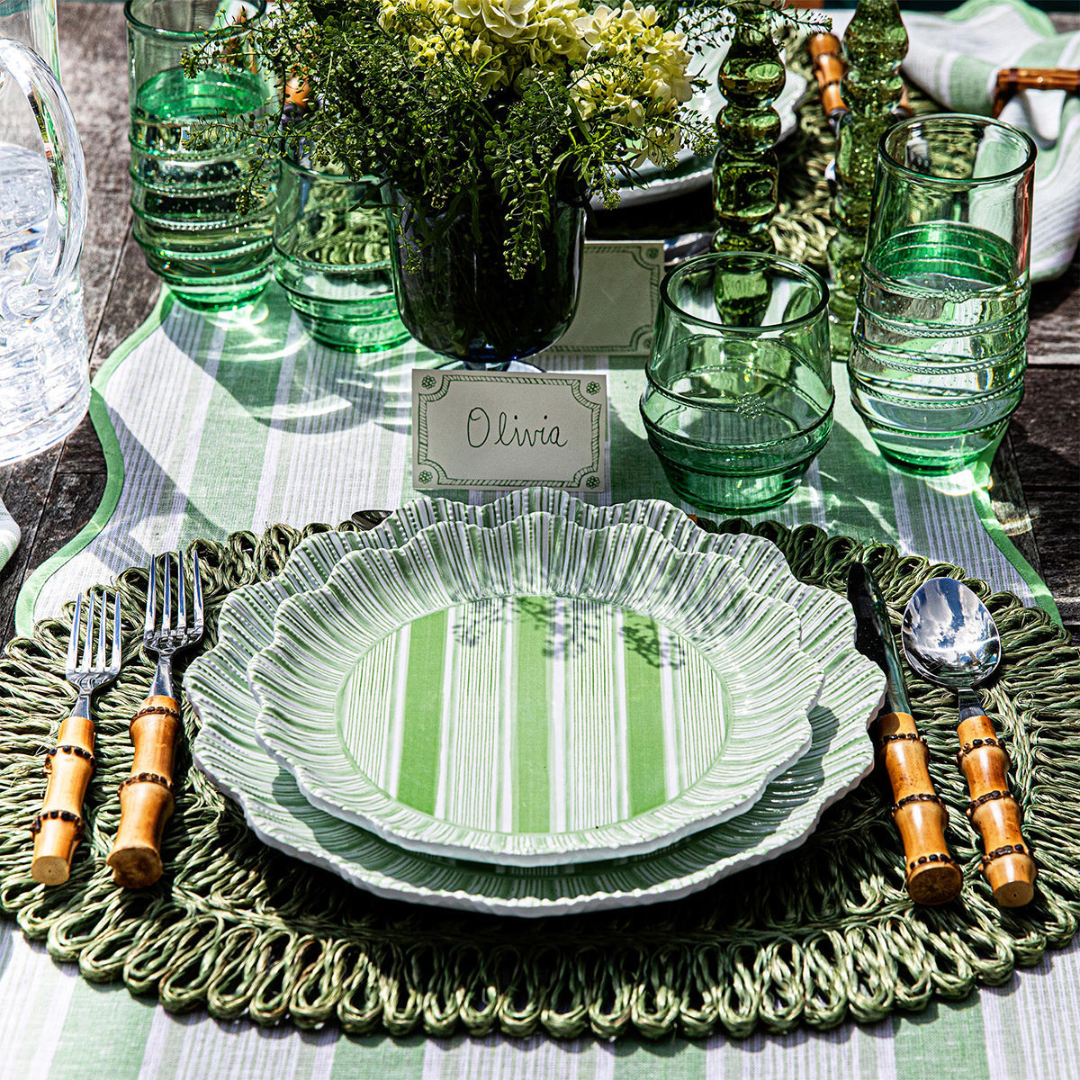 Berry & Thread place card above a green striped place setting with green glassware