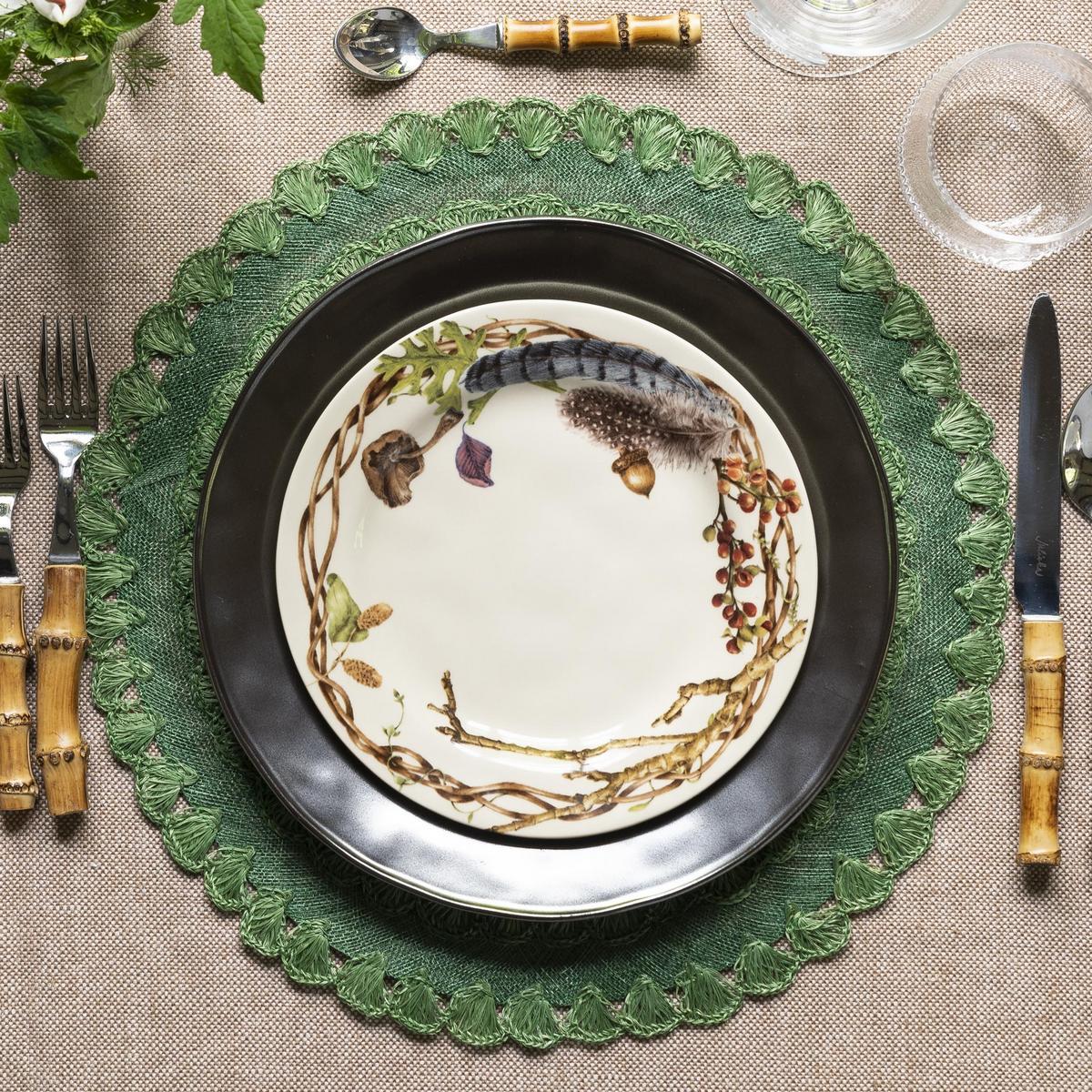 Forest Walk party plate on a black dinner plate and green charger with bamboo handled flatware
