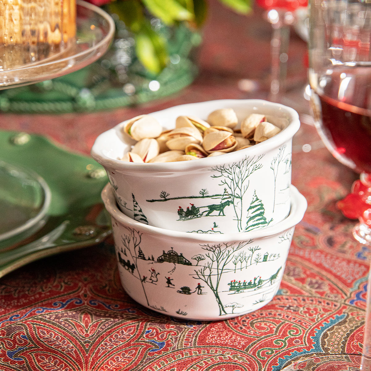 Stacked evergreen Winter Frolic ramekins holding pistachios