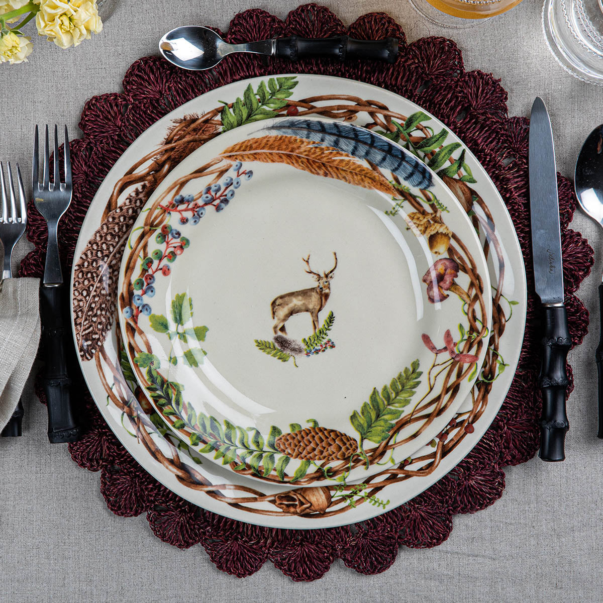 Forest Walk stag salad plate stacked on Forest Walk dinnerware over a woven placemat