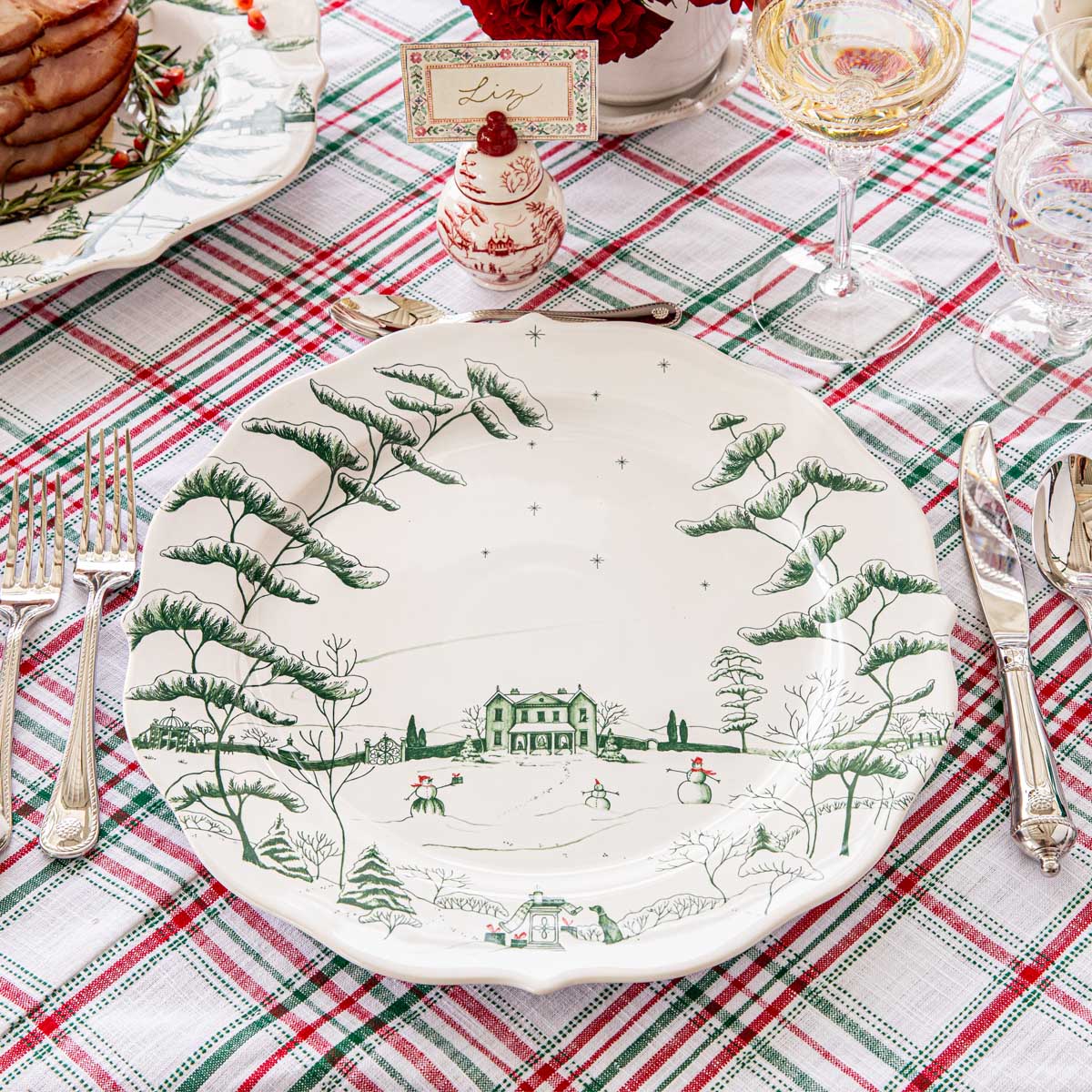 Evergreen Winter Frolic charger at a place setting on a plaid tablecloth