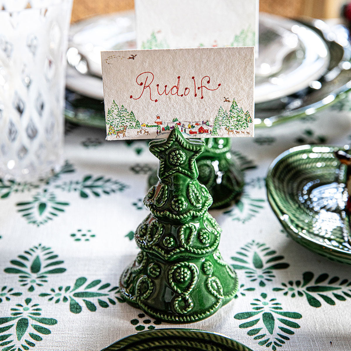 North Pole place card in a green tree place card holder on a holiday table