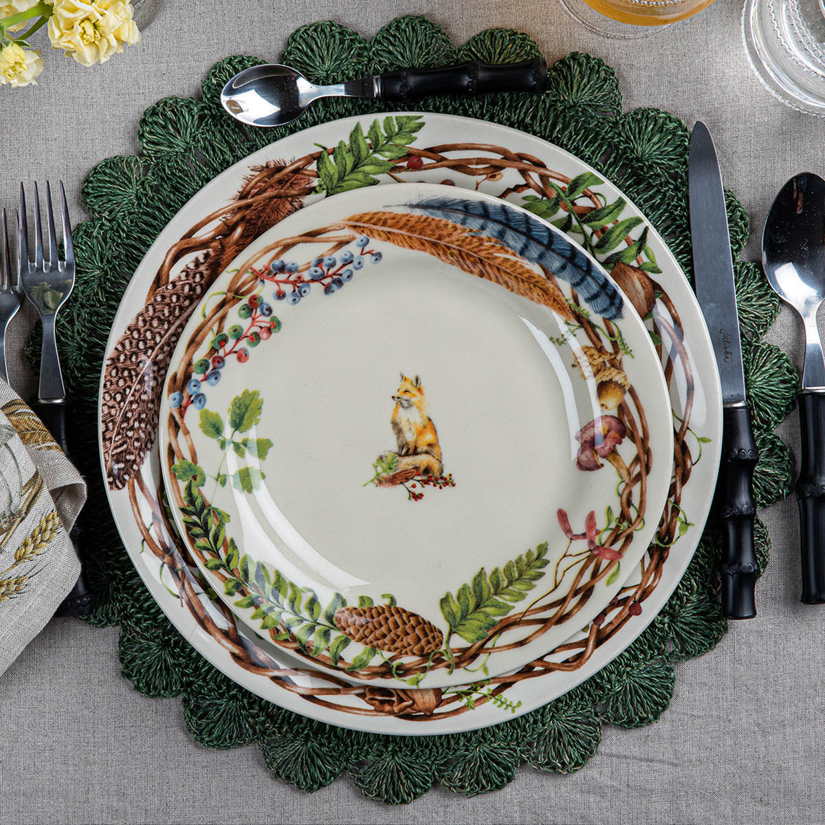 Forest Walk fox salad plate stacked on Forest Walk dinnerware over a green scalloped placemat