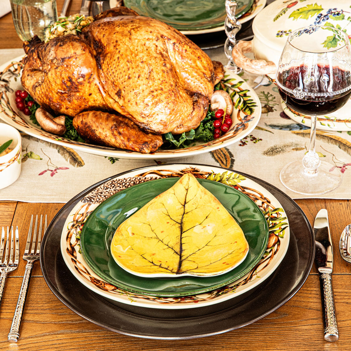Yellow Forest Walk leaf plate on a place setting with a roast turkey and red wine behind