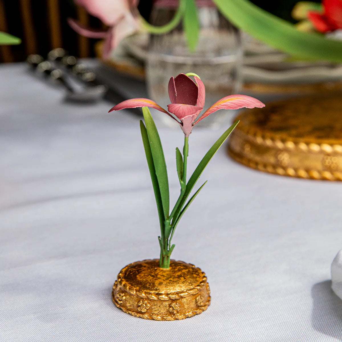 Juliska Meadow Walk place card holder with pink bloom and gold base on white linen table.