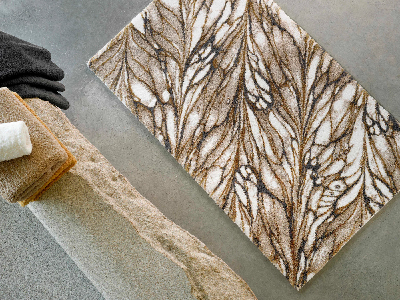 Close-up overhead view of Abyss Habidecor Diane bath rug with brown feather pattern.