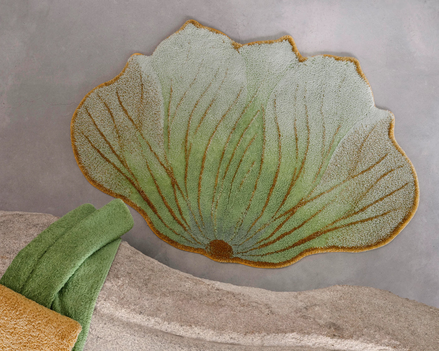 Abyss Habidecor Lotus bath rug in sage green with gold leaf veining, lotus petal shape.