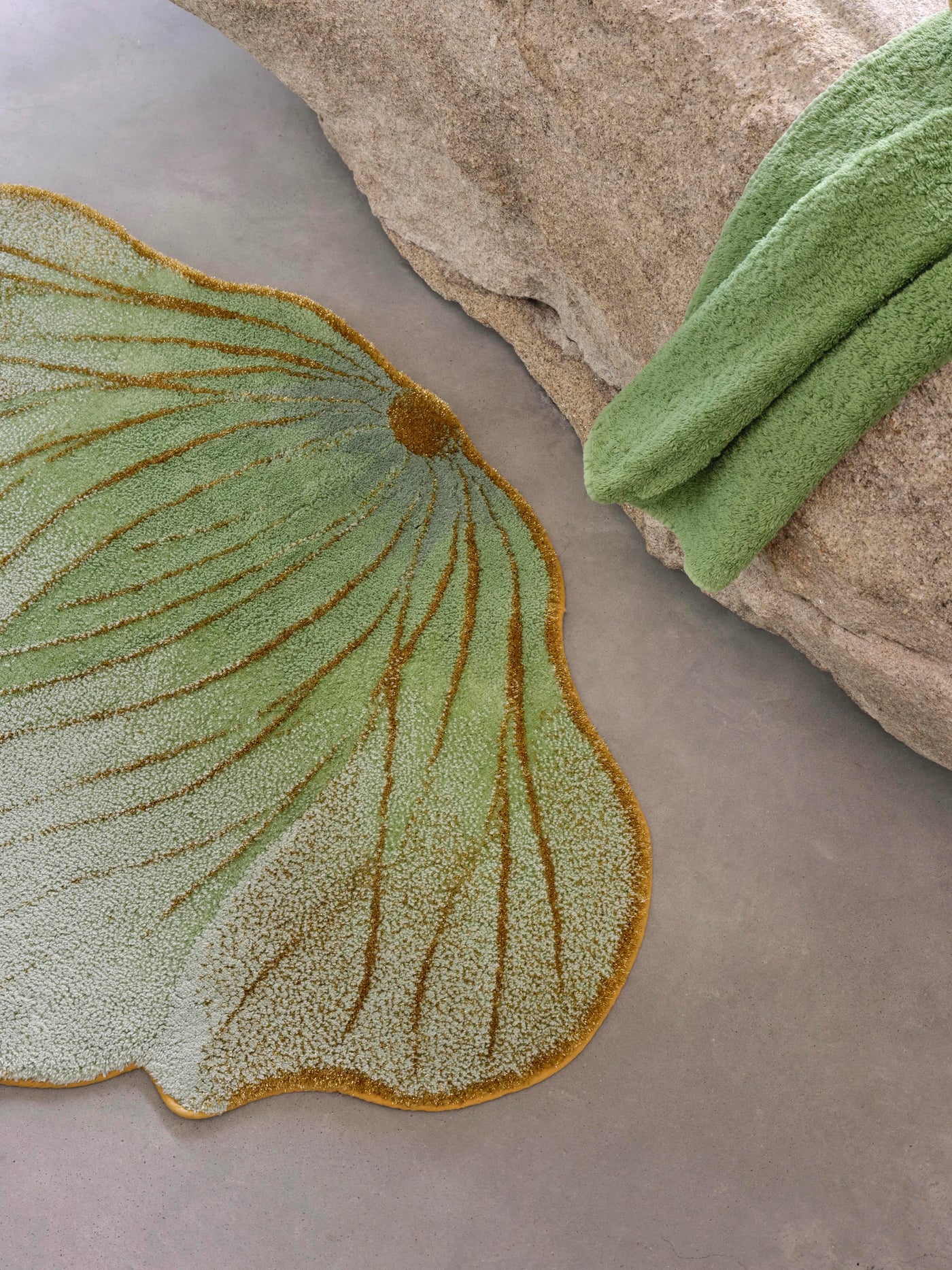 Close-up of Abyss Habidecor Lotus rug's sage and gold tufted leaf detail.
