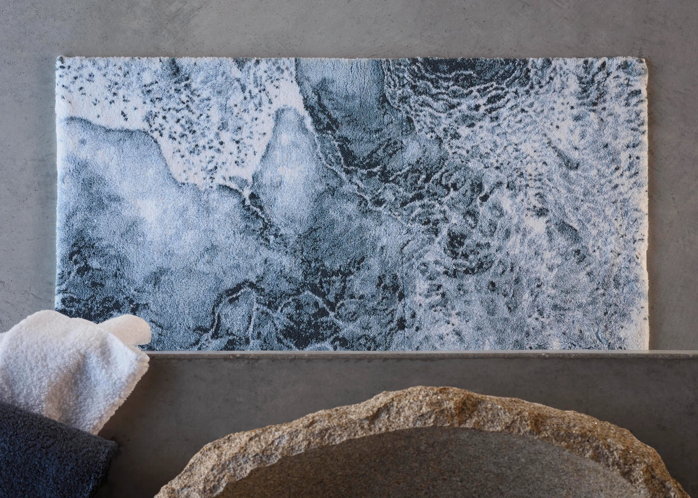 Abyss Habidecor Nazare bath rug with ocean wave print in slate and white.