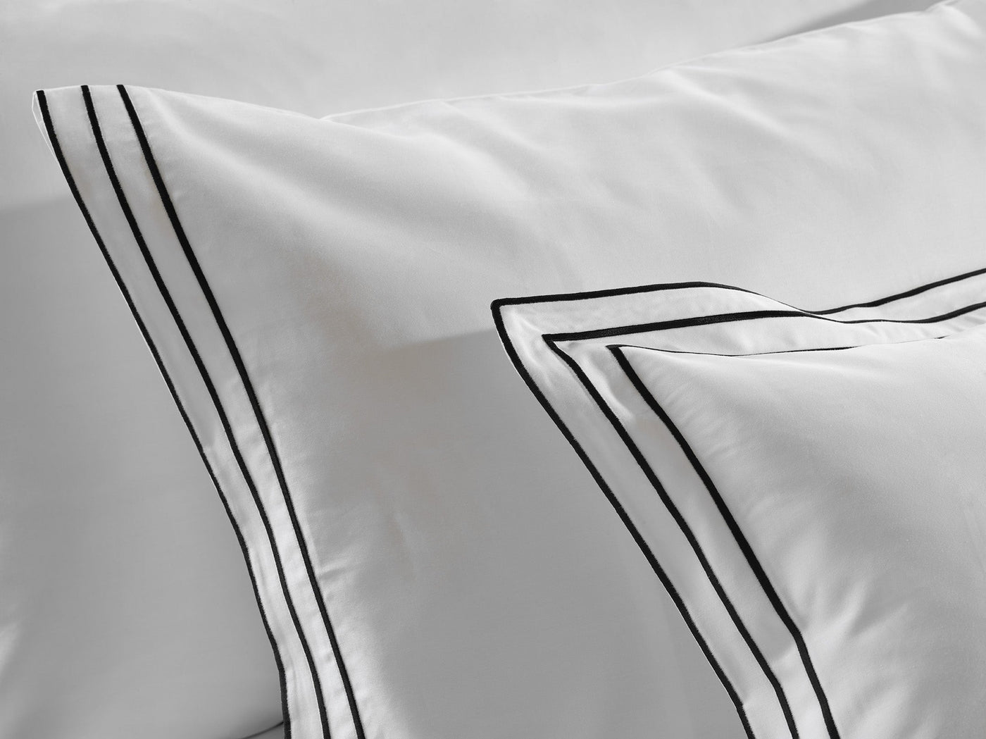 Close-up of triple black embroidered border detail on ivory Alba pillow sham.
