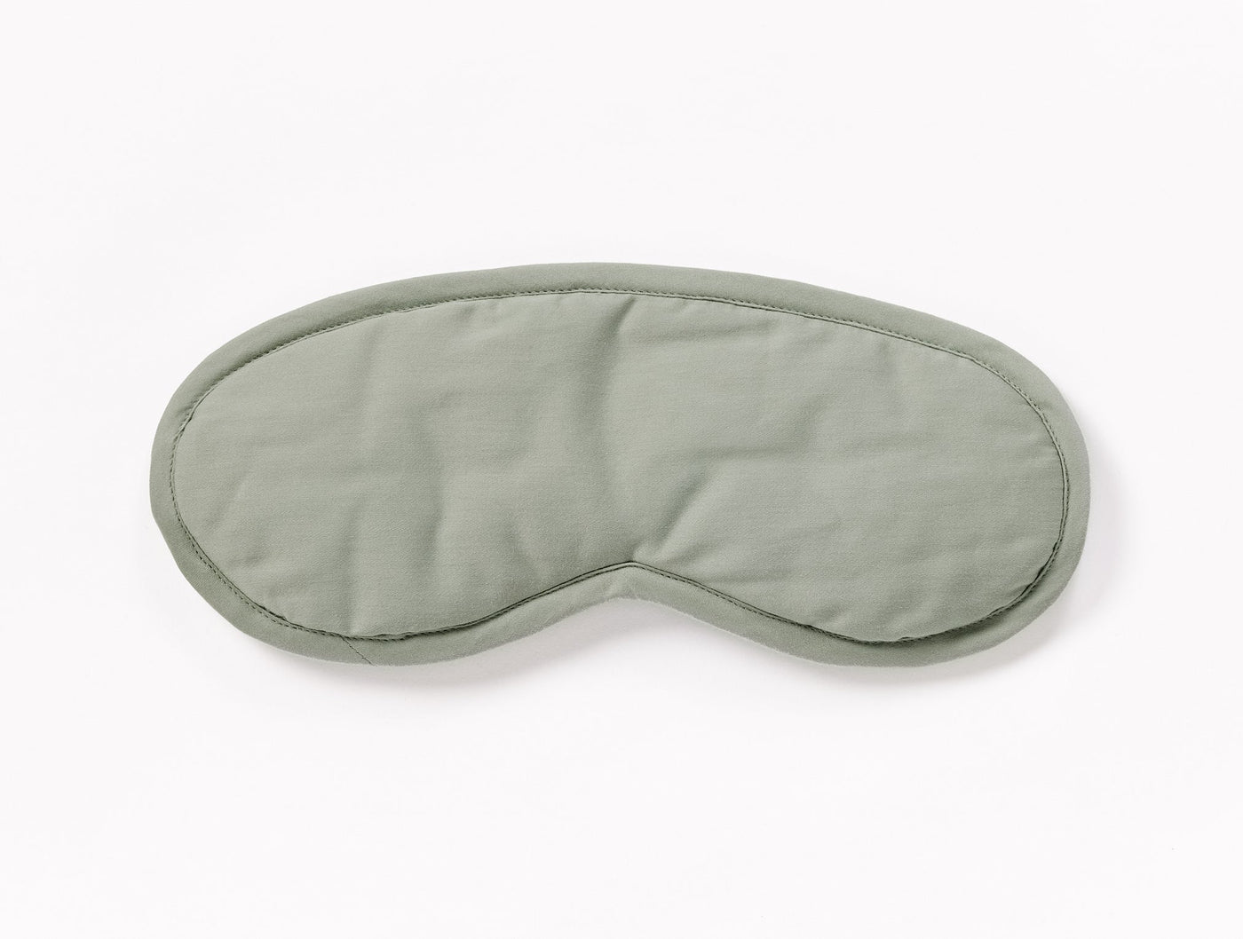 Sage green sateen eye mask with contrast piped edge, front view on white background.