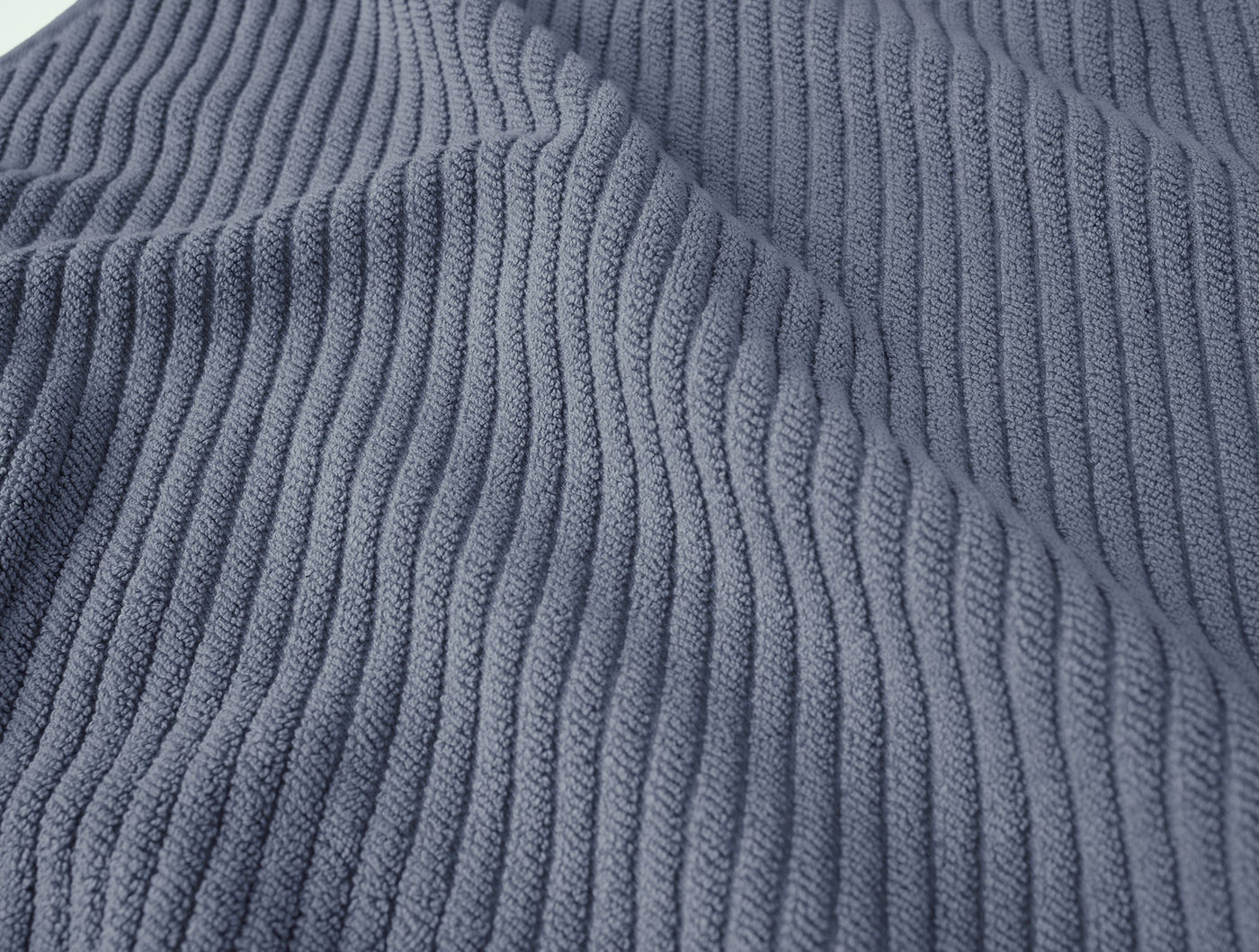 Close-up of slate blue ribbed cotton weave texture on Coyuchi Air Weight bath rug.