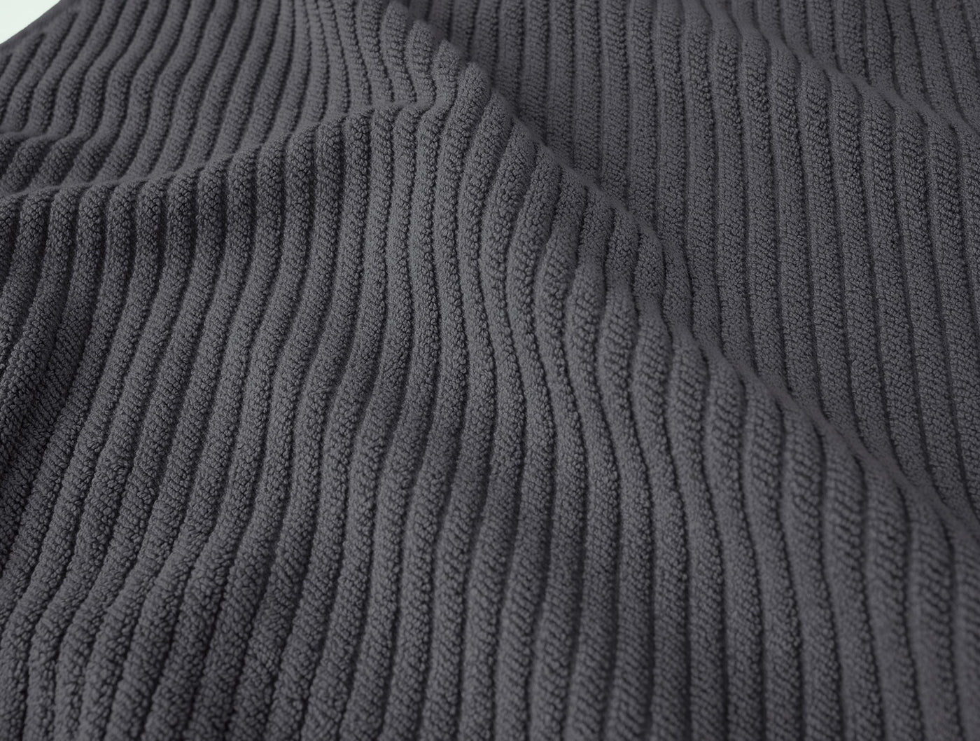 Close-up of Coyuchi Air Weight bath rug ribbed weave texture in charcoal.