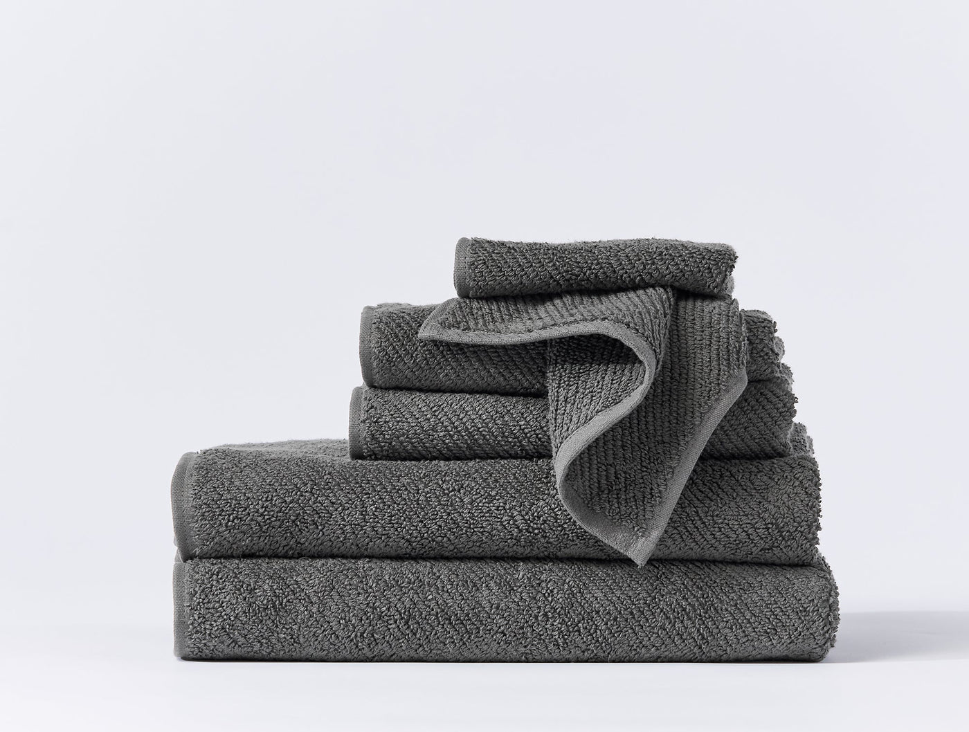 Coyuchi Air Weight wash cloth set stacked in slate grey, showing textured weave detail.