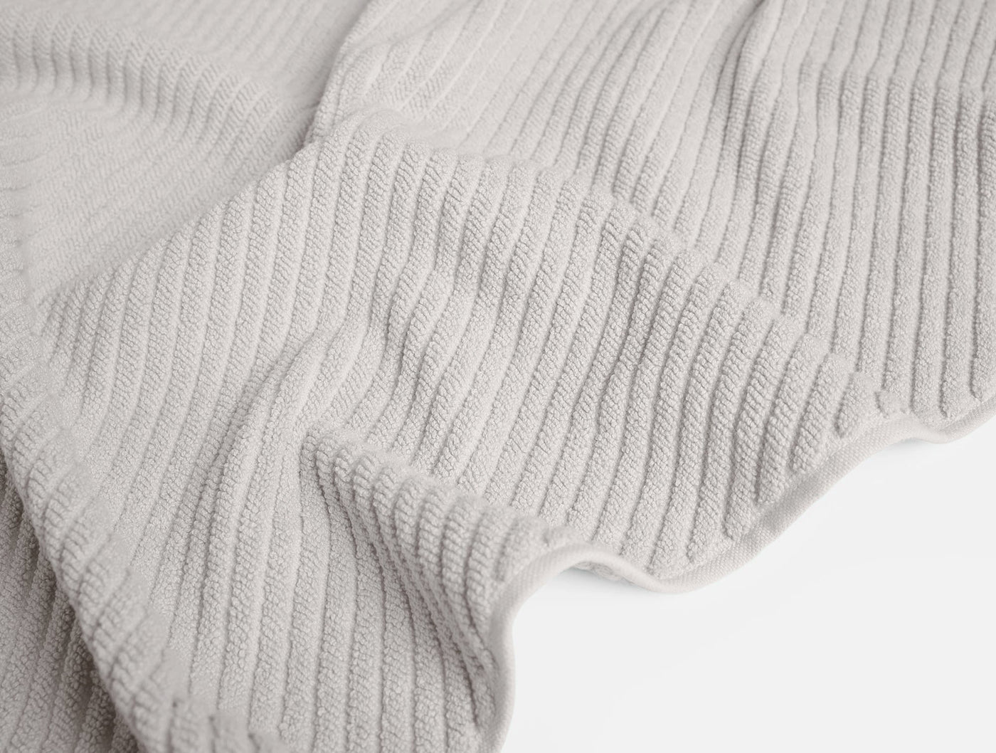 Close-up of Coyuchi Air Weight bath rug's ribbed cotton weave in pale grey.