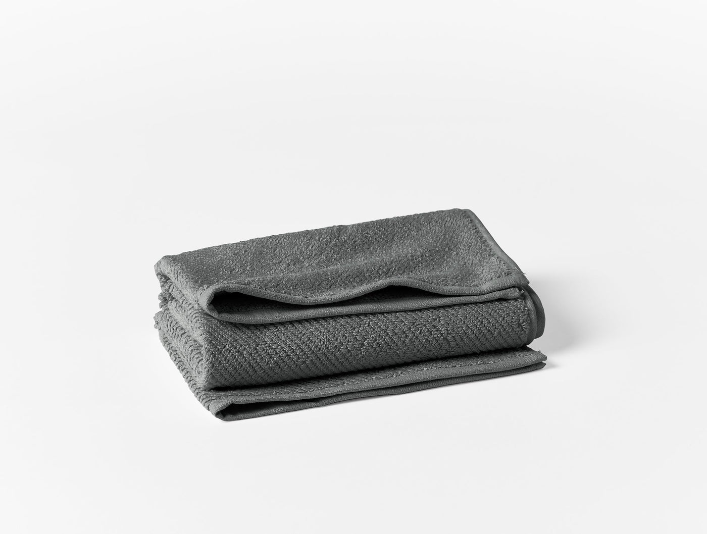 Coyuchi Air Weight wash cloths folded in charcoal gray, showing subtle woven texture.