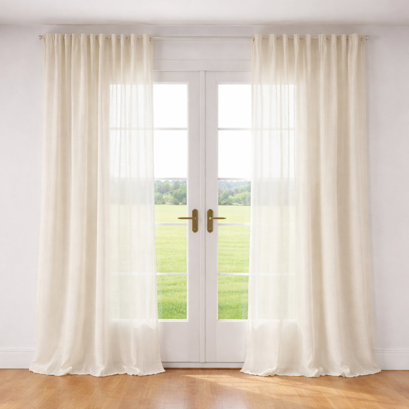 Ann Gish Akari ivory sheer curtain panels framing French doors in a sunlit room.