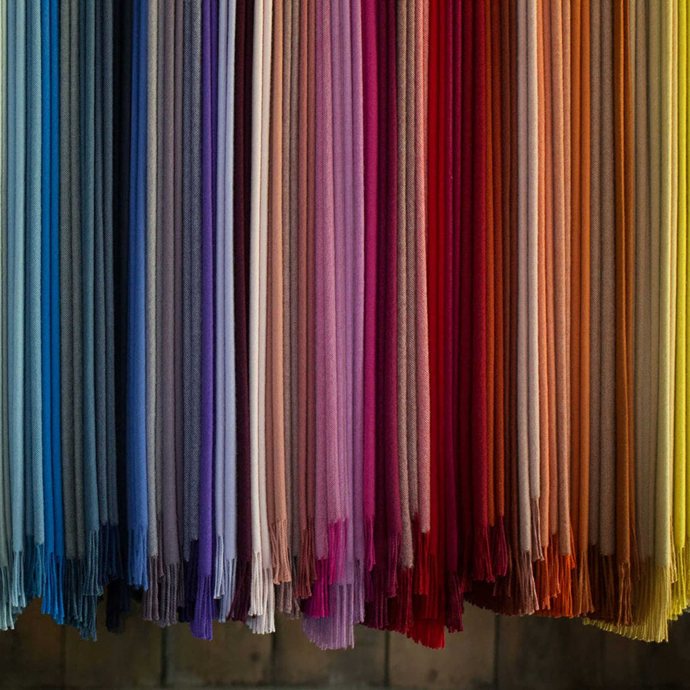 Row of colorful scarves in various hues on a dark background