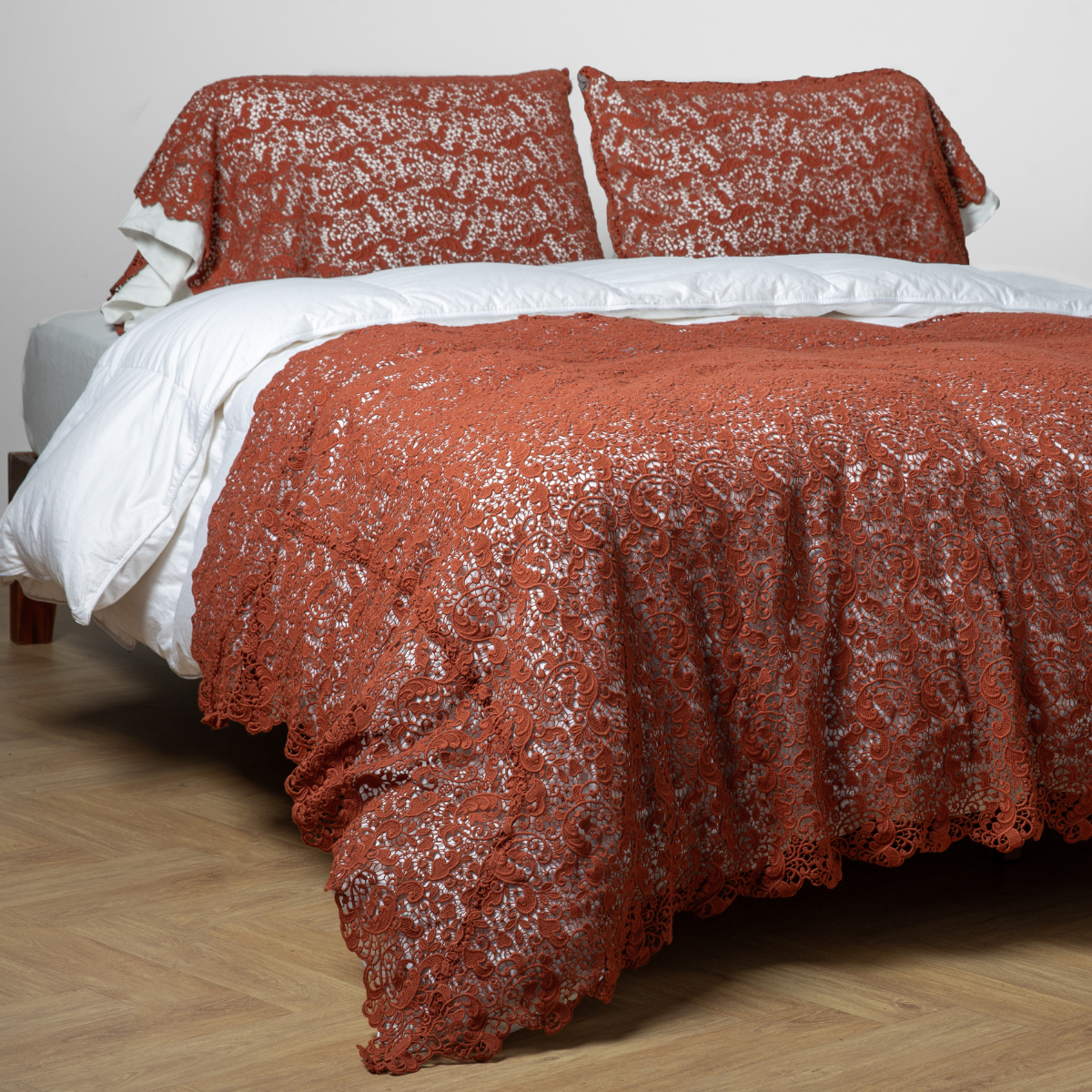 Autumn lace bed scarf draped over a made bed with matching pillow shams.