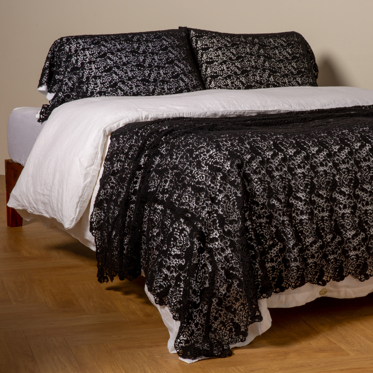 Bella Notte Allora bed scarf in Corvino draped over white bedding, with matching shams.