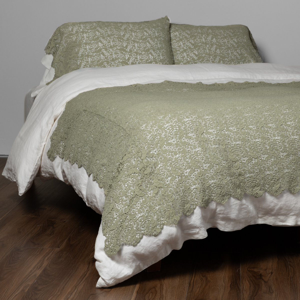 Desert Sage Allora bed scarf draped over bed with white linen, lace texture detail.