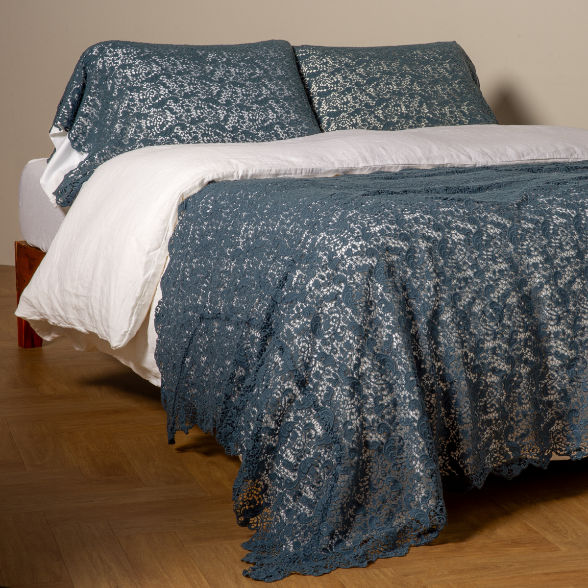 Midnight Allora lace bed scarf draped over white bedding, with matching pillow shams.
