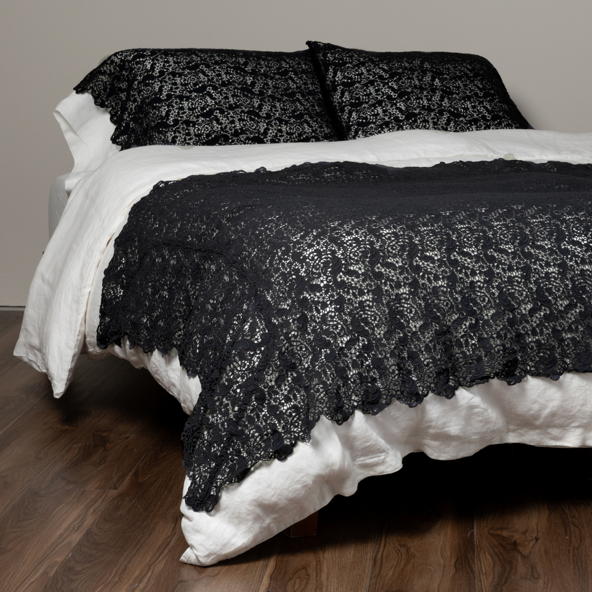 Bella Notte Allora bed scarf in Slate draped over white bedding with matching shams.