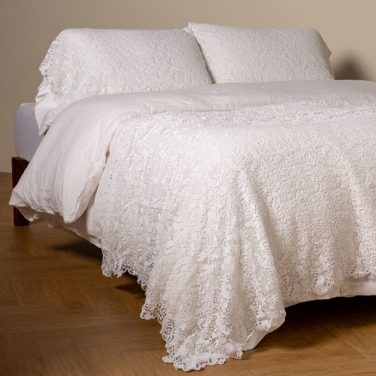 Bella Notte Allora bed scarf in White with floral lace trim draped across a made bed.