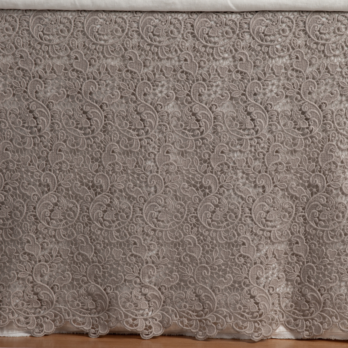 Close-up of Bella Notte Allora bed skirt in Fog, showing intricate scrolling lace floral pattern.