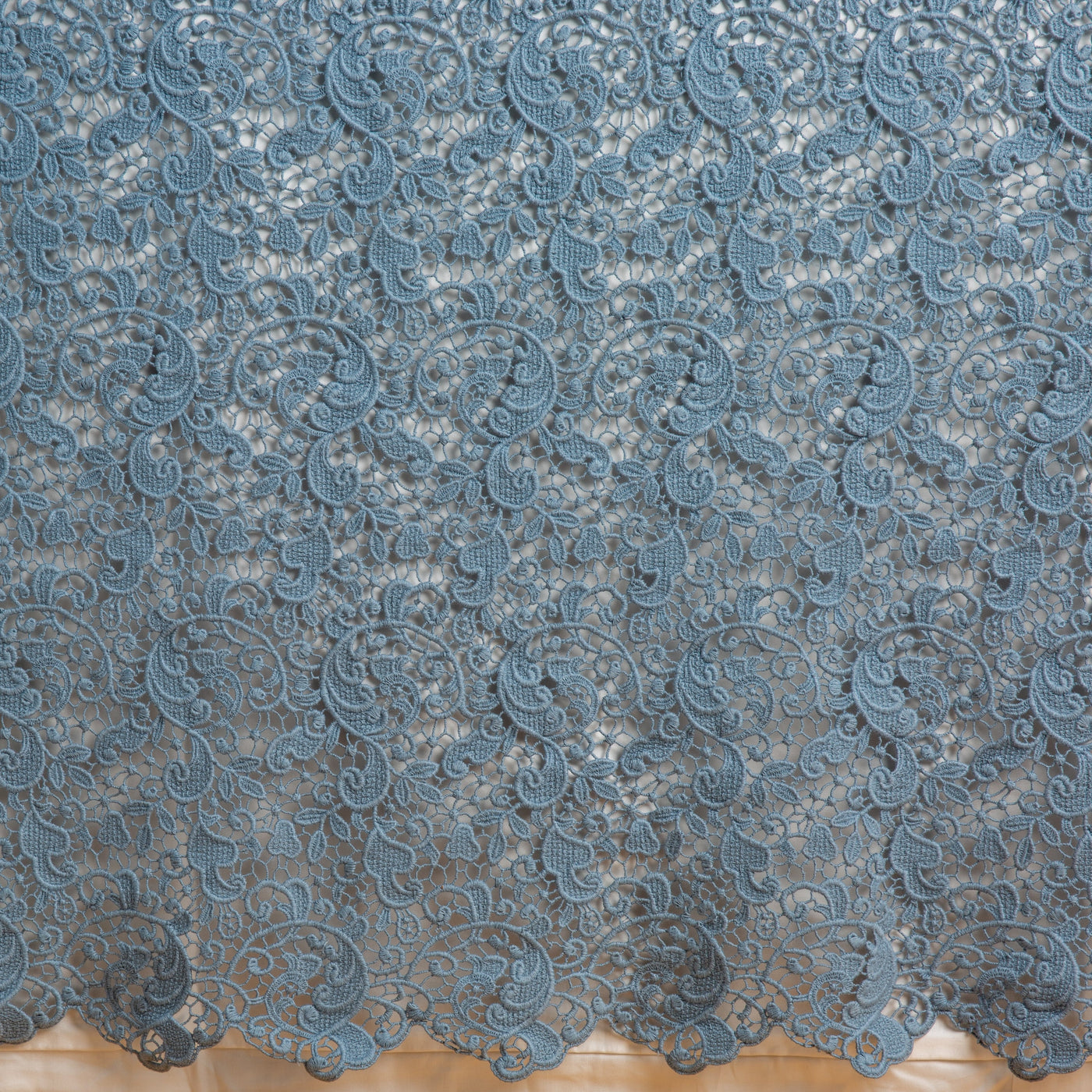 Close-up of Tahoe Blue lace bed skirt hem with intricate scrolling floral guipure pattern.