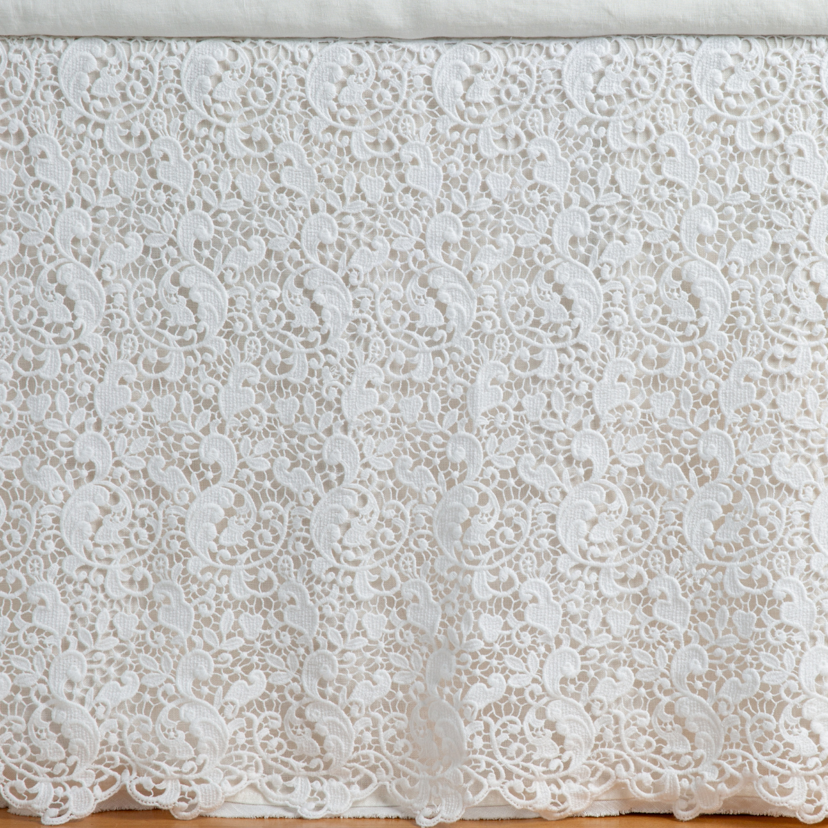 Bella Notte Allora bed skirt in Winter White, intricate floral lace panel draped on bed.