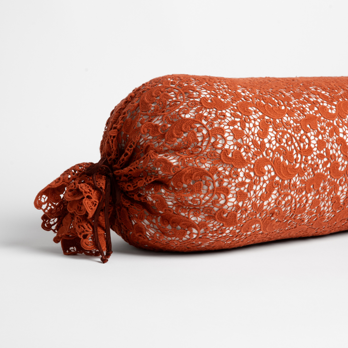 Autumn lace bolster throw pillow with gathered floral lace end detail, angled view.