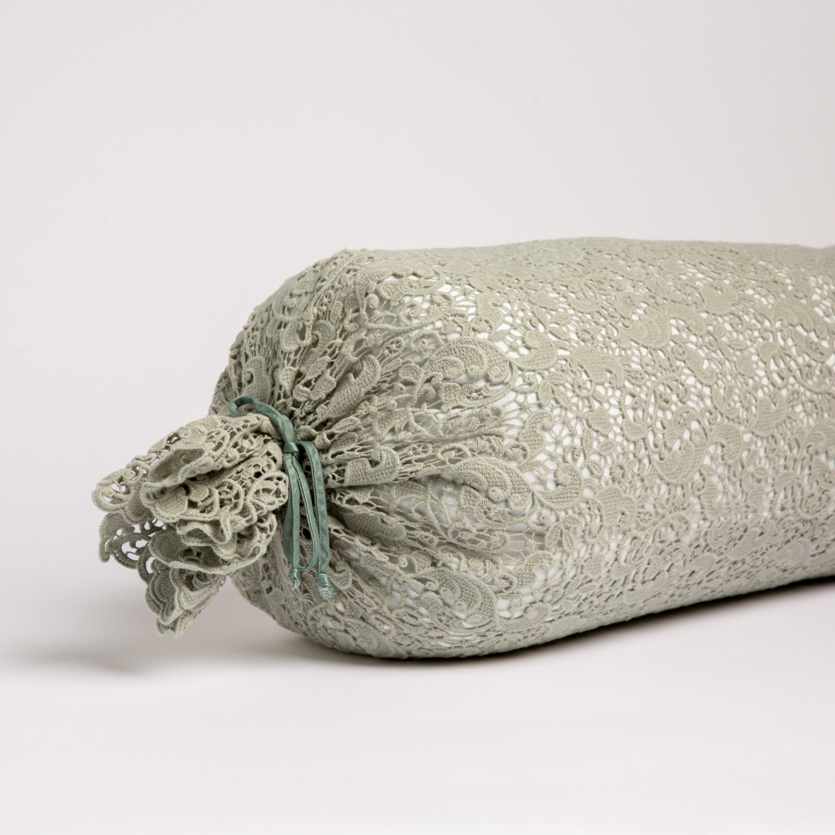 Eucalyptus bolster end detail showing gathered lace trim tied with a satin ribbon.