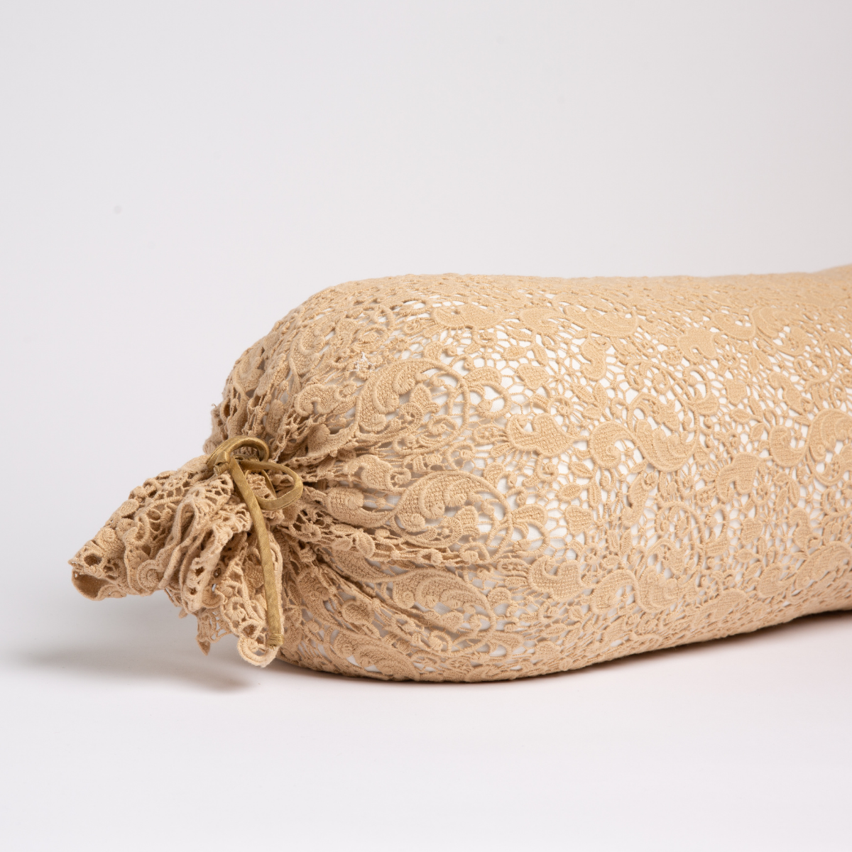 Close-up of Bella Notte Allora Lace bolster in Honeycomb, gathered lace tie at end.