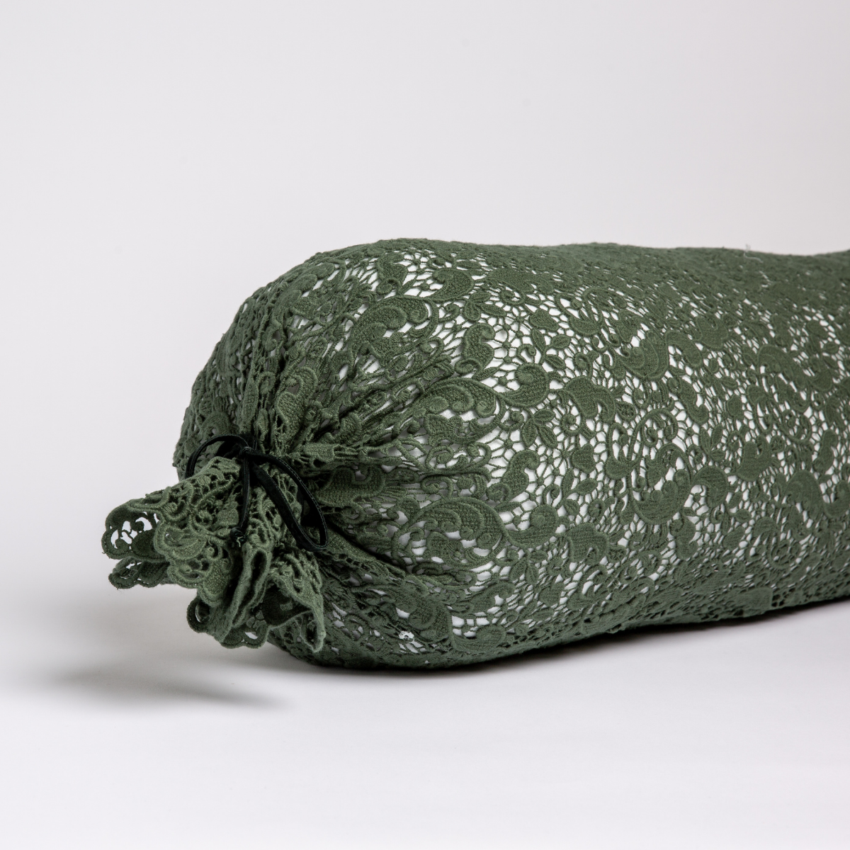 Close-up of Juniper Allora Lace bolster pillow with intricate floral lace overlay and tied ends.