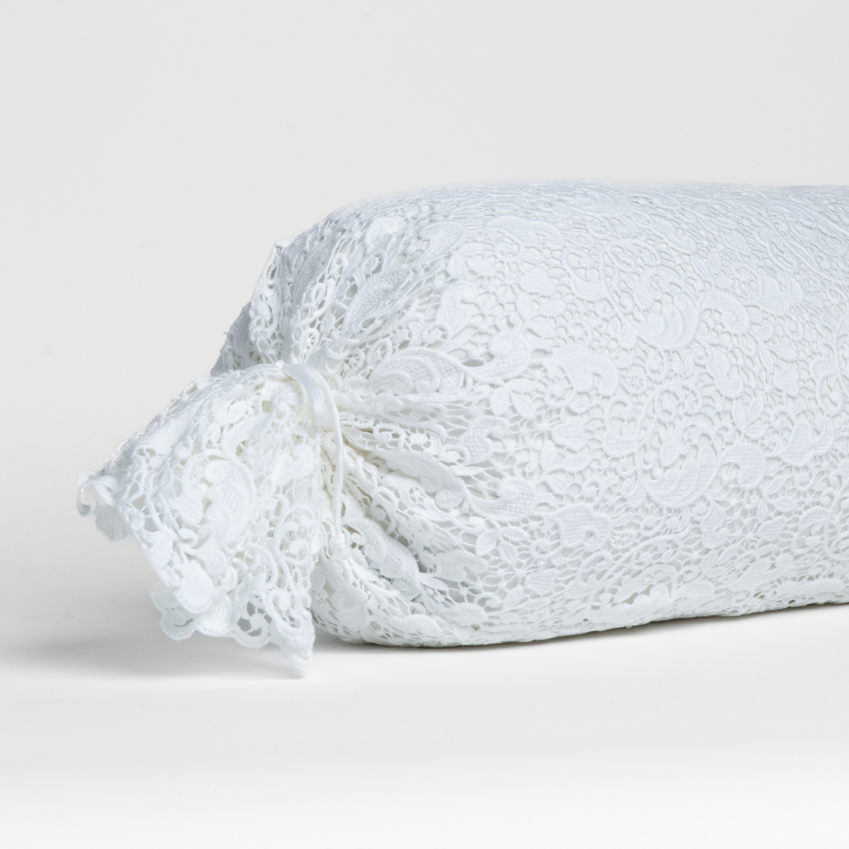 Bella Notte Allora Lace throw pillow in White with floral lace detailing and tied end.