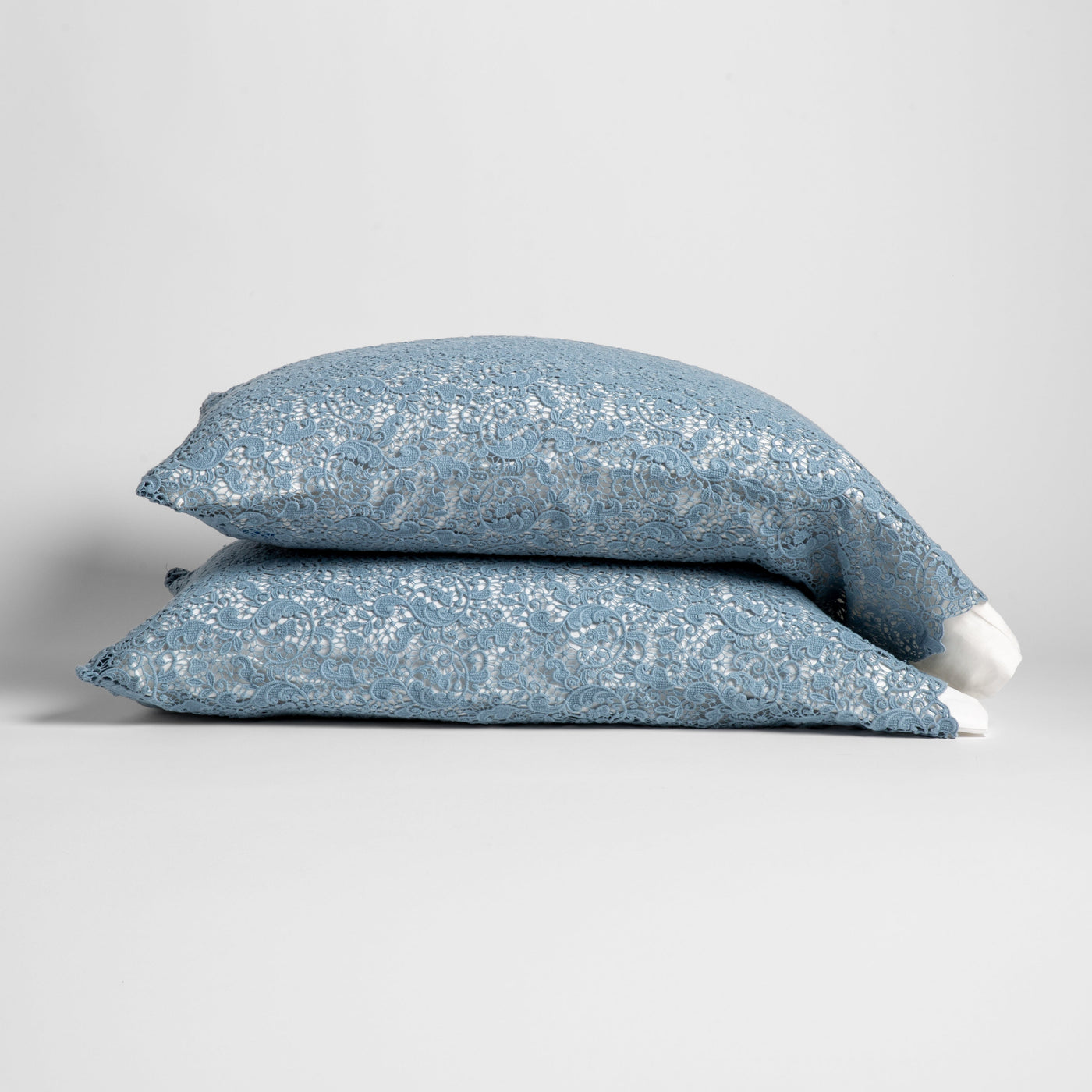 Bella Notte Allora Lace pillowcases stacked in Tahoe Blue, showing delicate lace pattern detail.