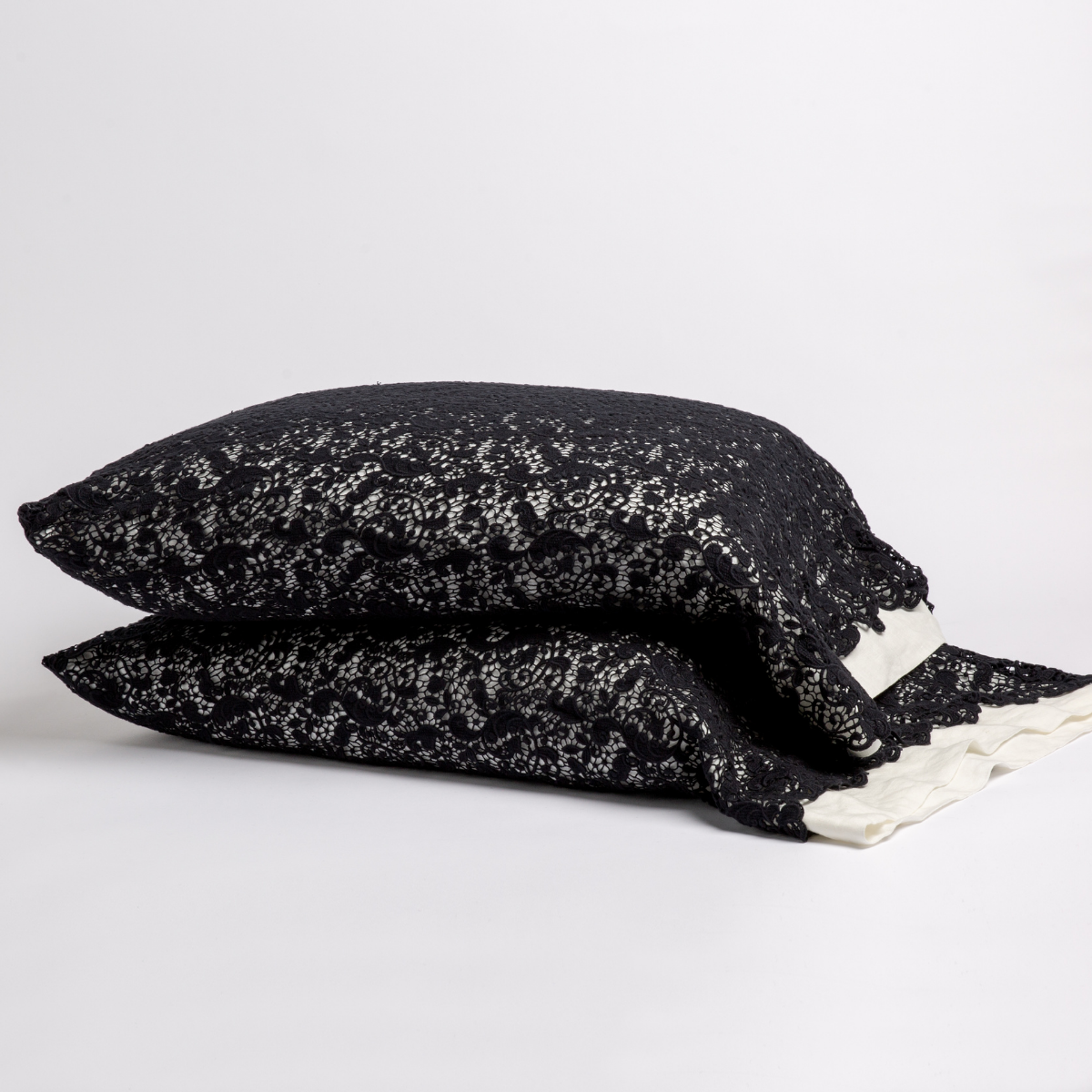 Two stacked Corvino pillowcases with delicate lace trim visible at edge.