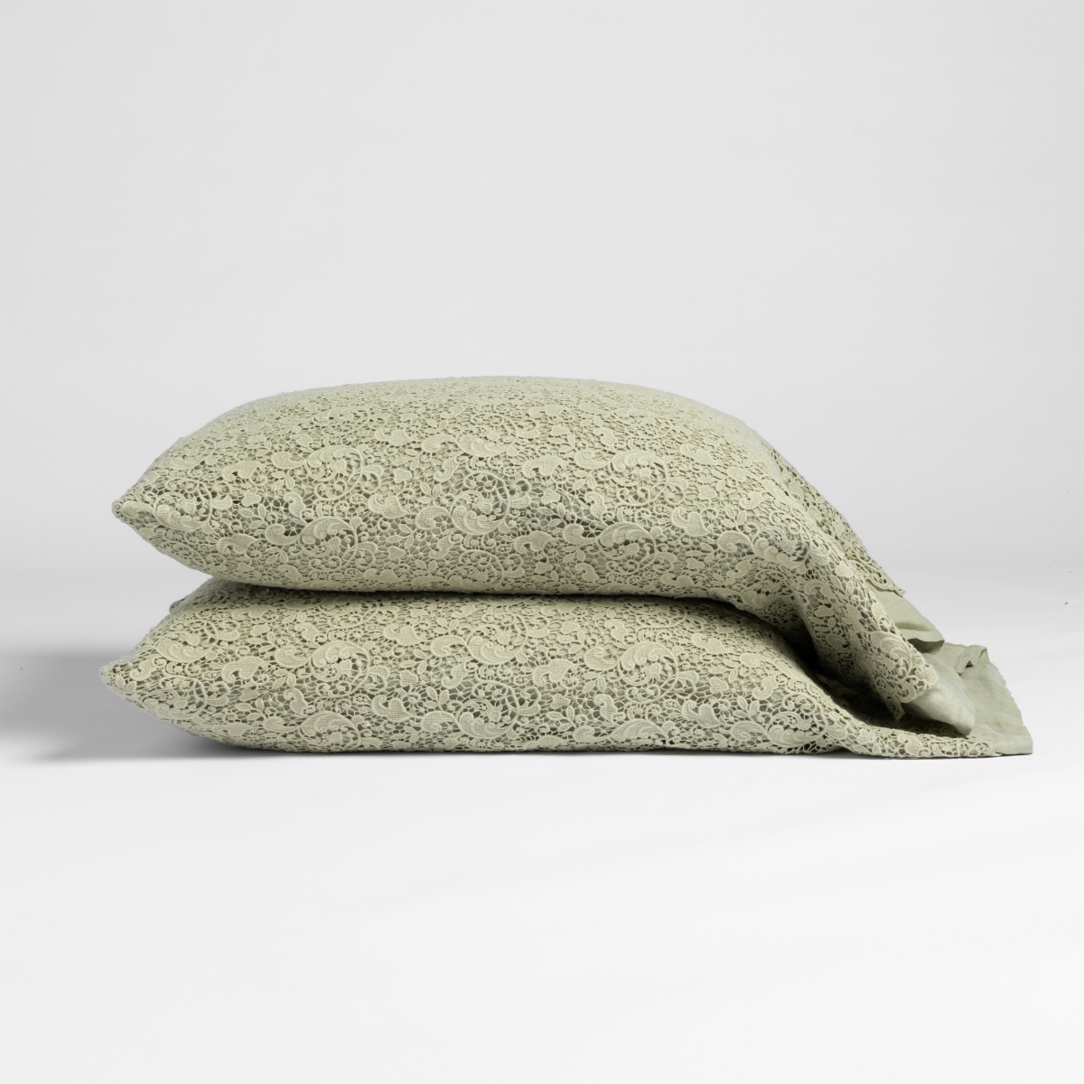 Two Desert Sage Bella Notte Allora Lace pillowcases stacked, showing delicate lace floral pattern.
