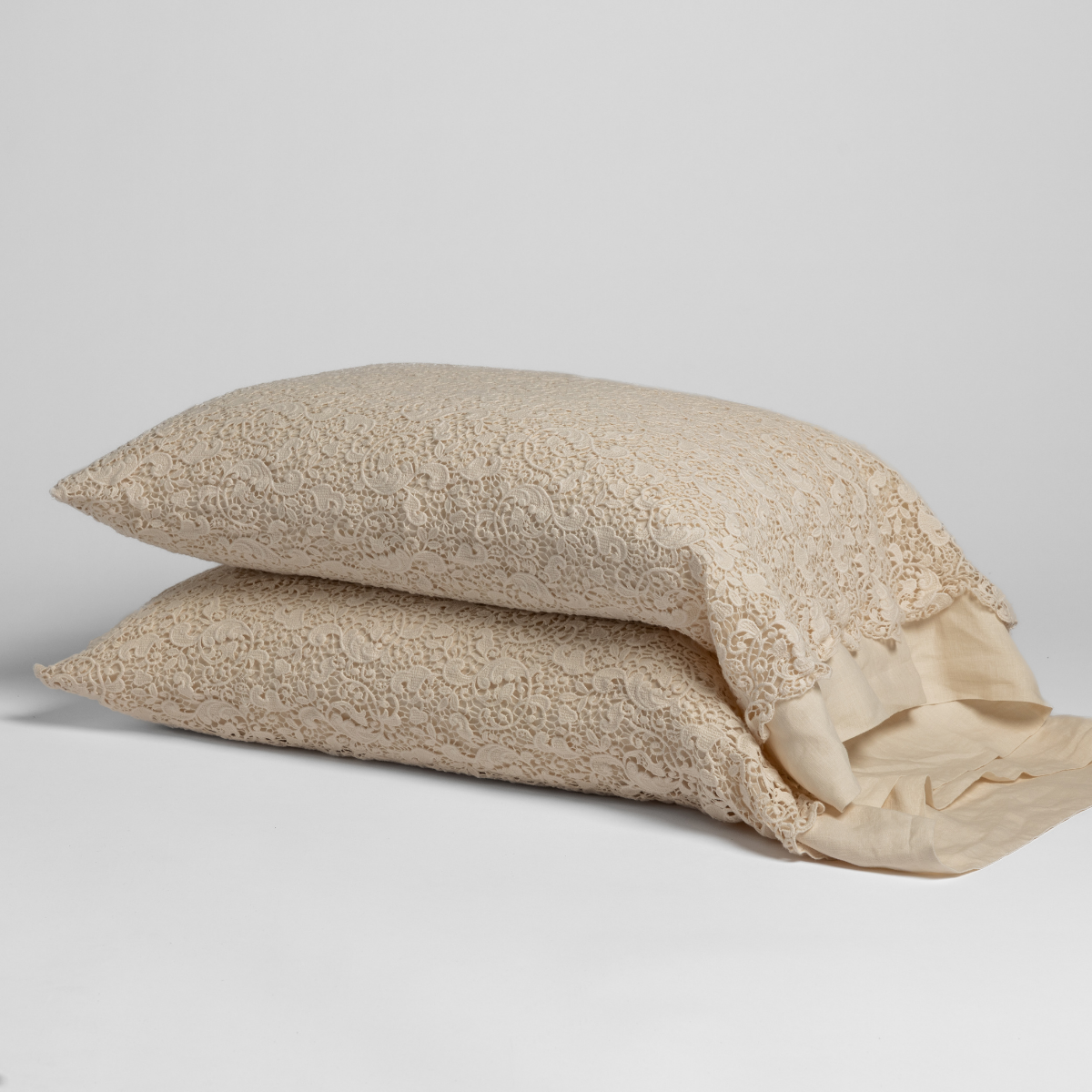 Two Natural Allora Lace pillowcases stacked, showing floral lace overlay and contrast sateen reverse.